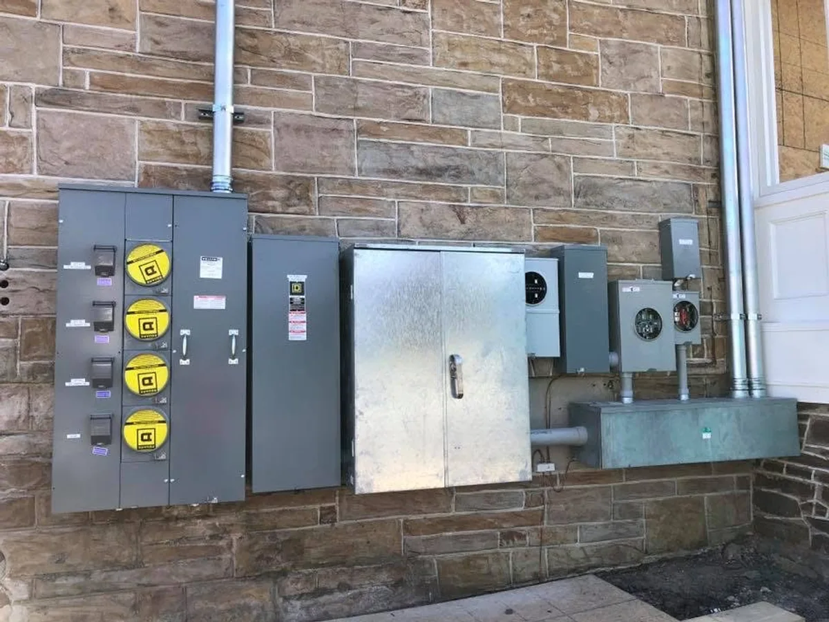 Multi-panel commercial electrical system on stone building — finished
