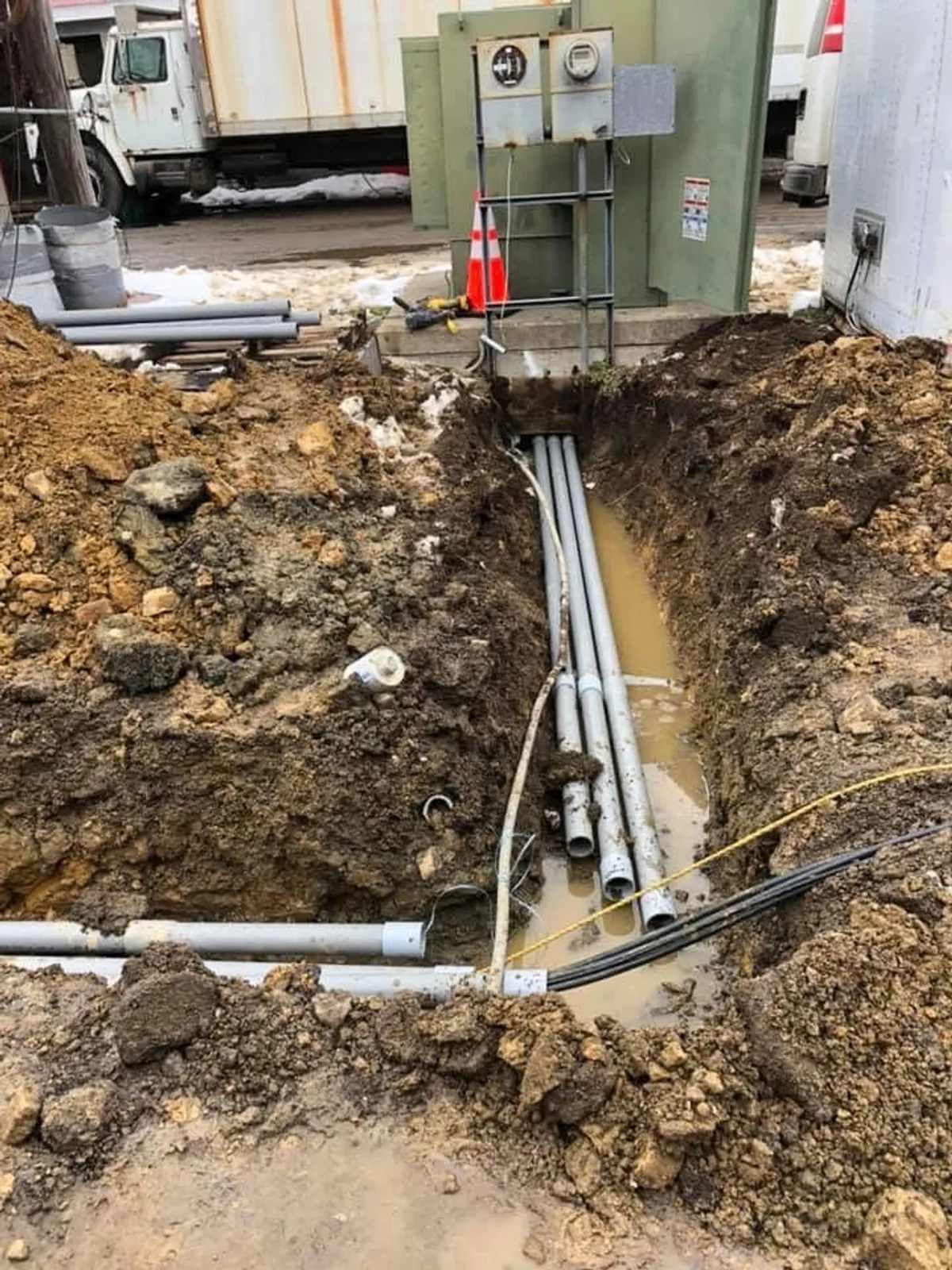 Underground conduit installation in excavated trench